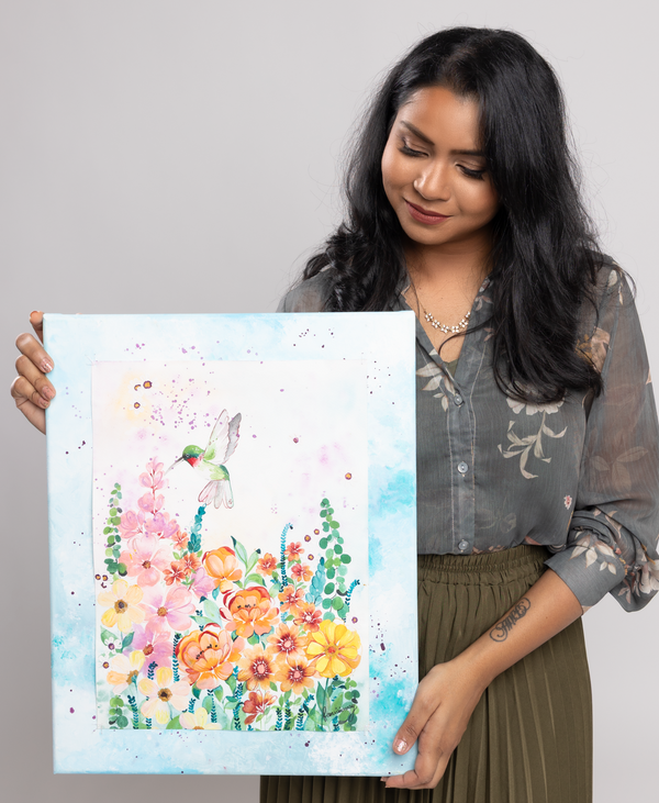 Femvisionary holding a colorful floral painting against a plain background